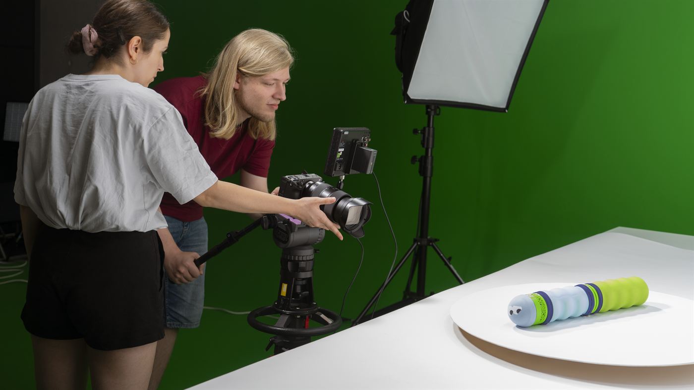 Zwei Teammitglieder richten im Studio Kamera und Licht auf die Maupe aus.