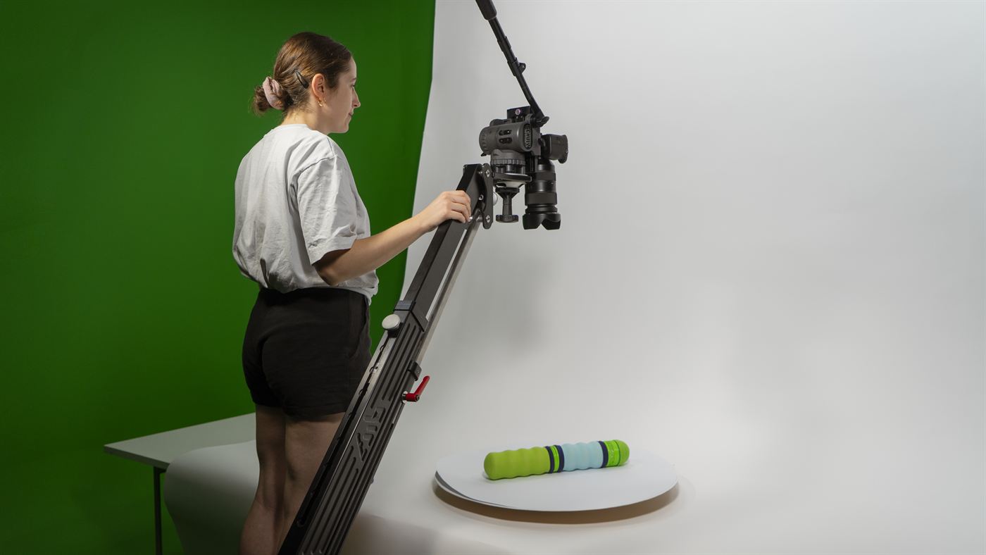Ein Teammitglied stellt die Kamera vor dem Greenscreen ein, die Maupe liegt auf einem Drehteller.