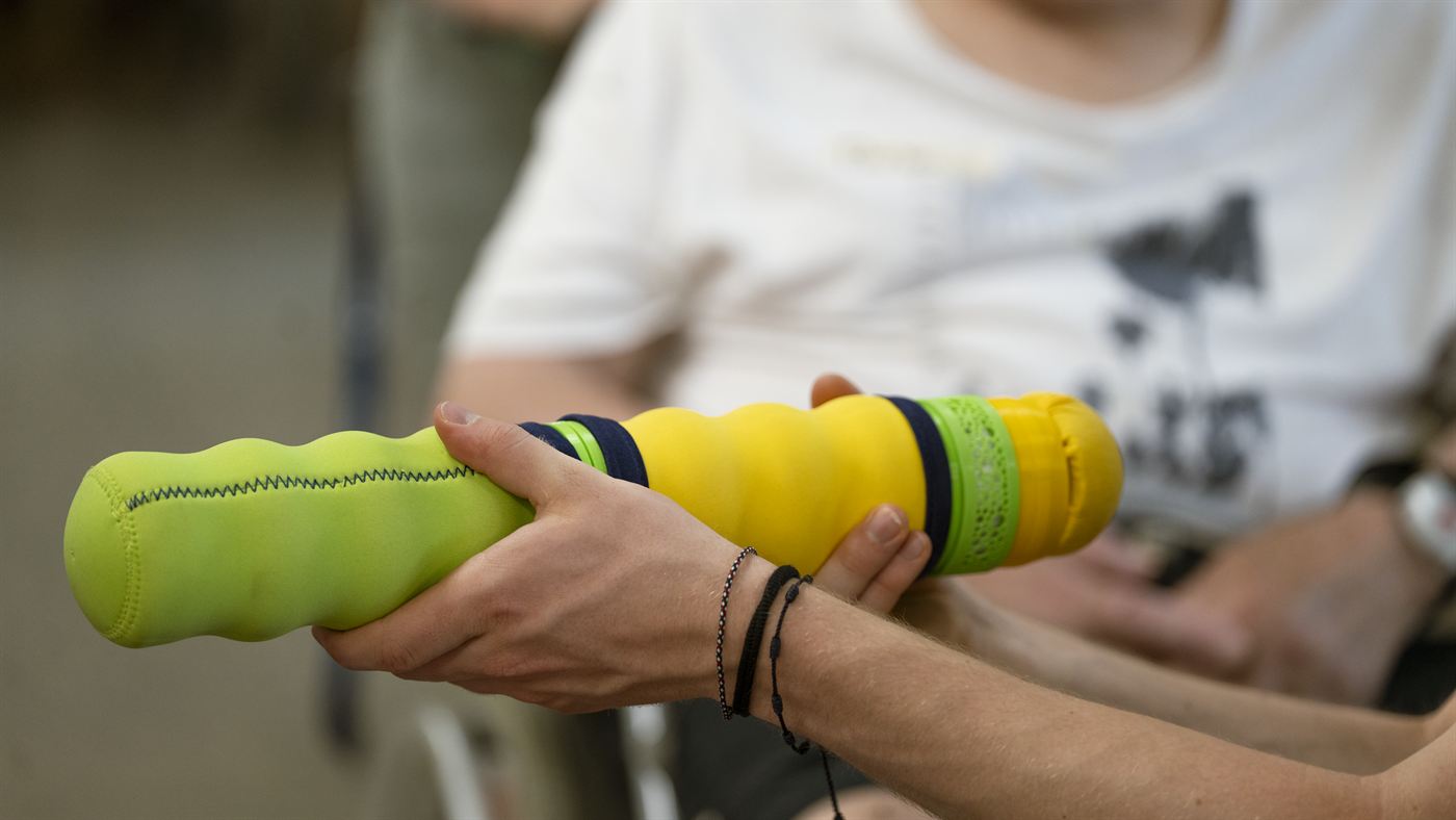 Nahaufnahme: eine Hand umfasst die grünen Segmente des Maupe-Körpers.