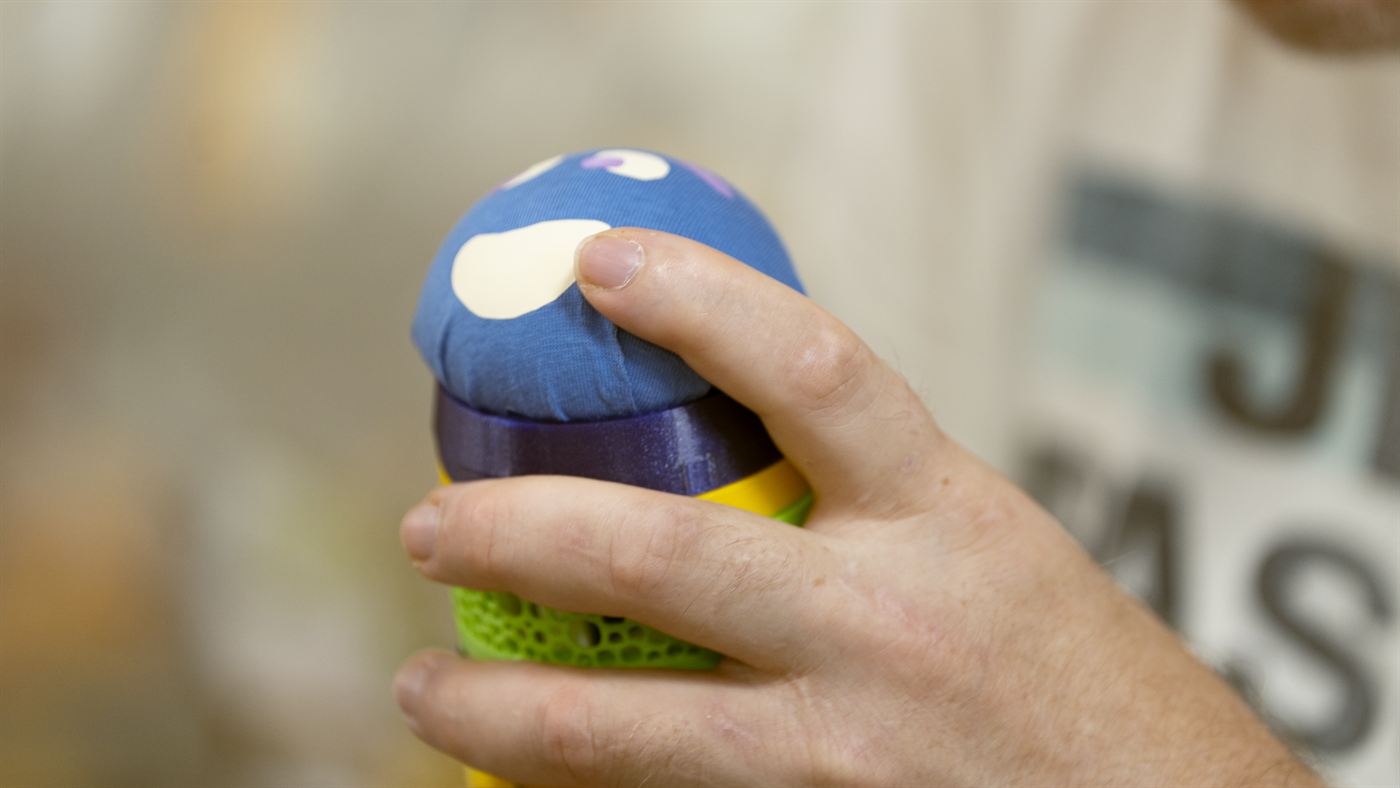 Eine Hand hält den blauen Maupe-Kopf mit dem weißen Punkt.