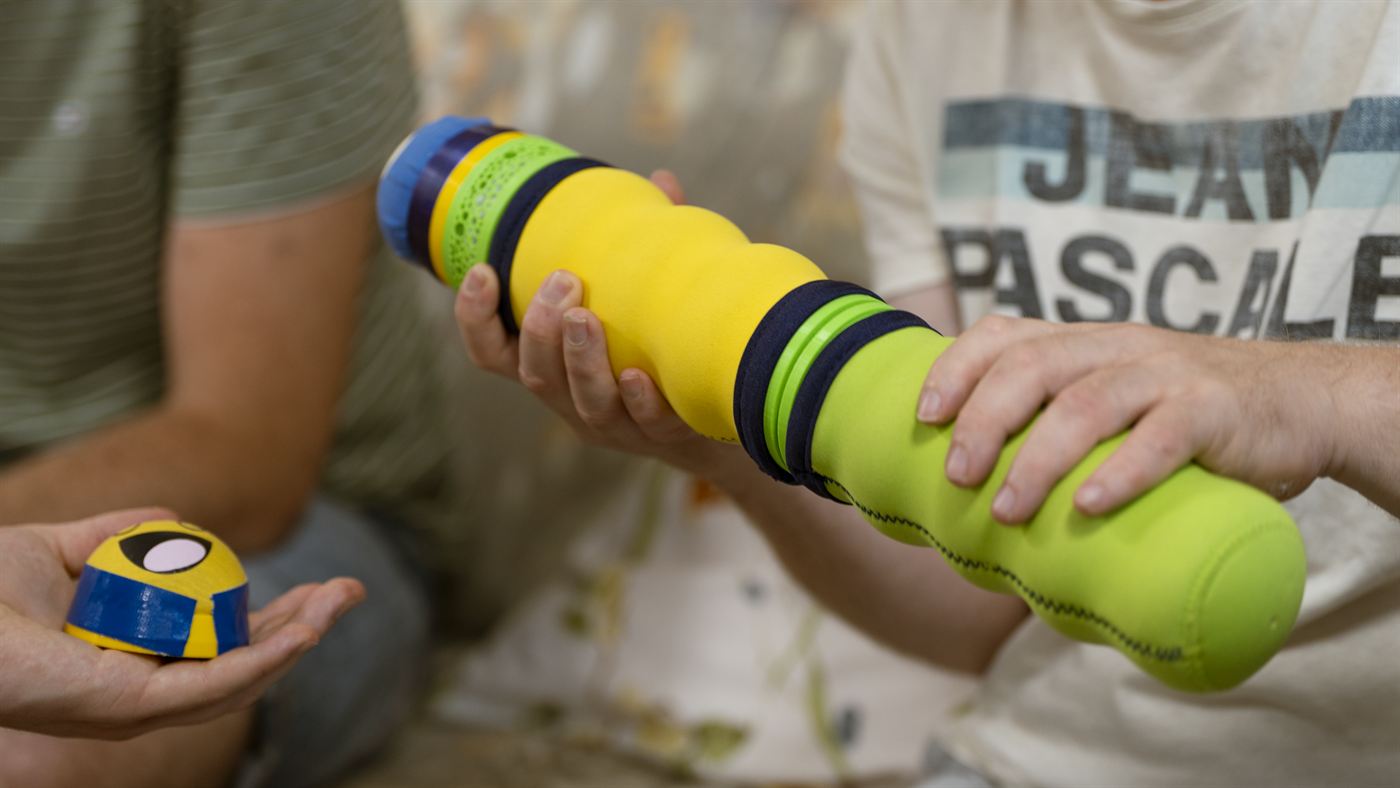 Die Maupe liegt auf einem Arm, der Kopf wird separat in der anderen Hand gehalten.