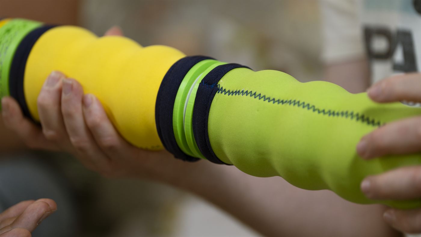Nahaufnahme: die Maupe liegt quer auf einem Unterarm, eine Hand am Körper.
